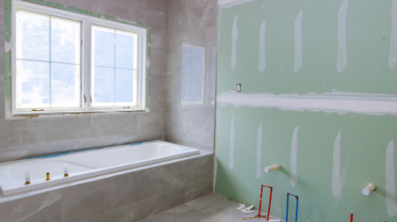 Plumber installing pipes in a bathroom remodel project with new tiles