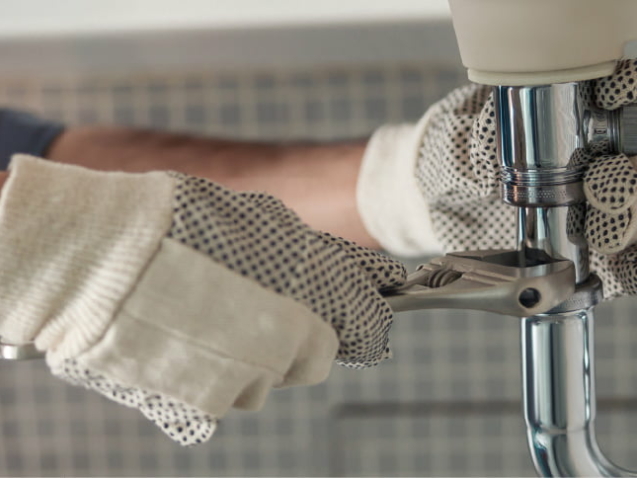 Professional plumber fixing a leaking pipe.