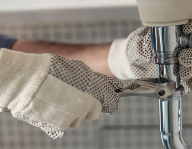 Professional plumber fixing a leaking pipe.