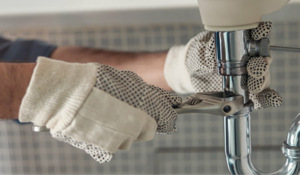 Professional plumber fixing a leaking pipe.