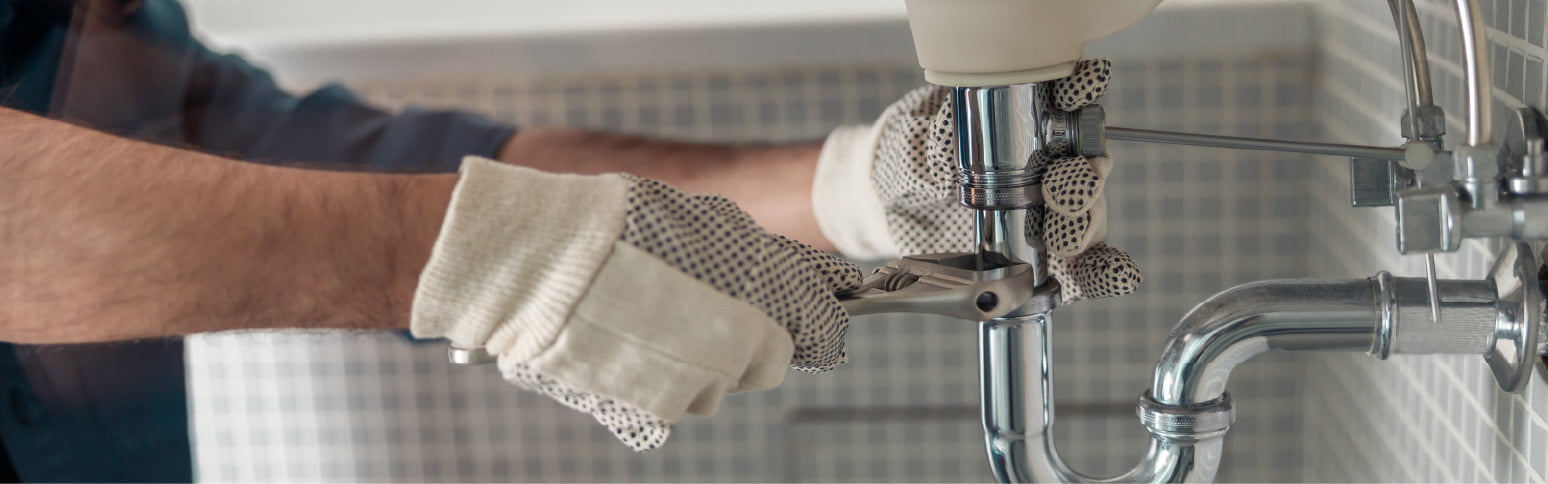 Professional plumber fixing a leaking pipe.