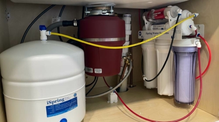 Plumber in Nashville, TN installing a water filtration system in a kitchen