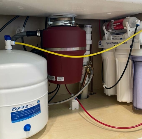 Plumber in Nashville, TN installing a water filtration system in a kitchen