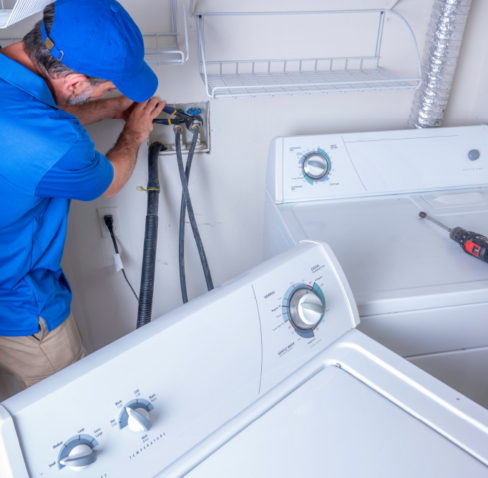 Plumber installing a washer and dryer