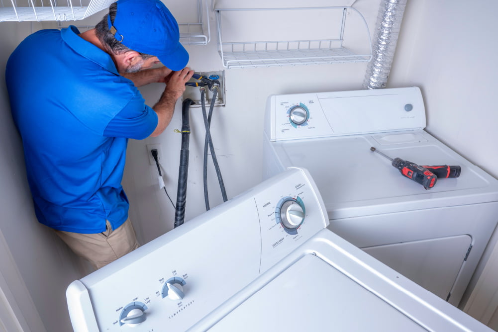 Plumber installing a washer and dryer