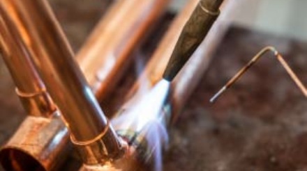Nashville plumber from ALL PIPES skillfully welding copper piping